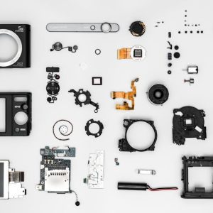 Flat lay of various disassembled camera components on a white background.